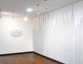 Trecho da instalação "Sob Medida" | Ao fundo, texto da exposição